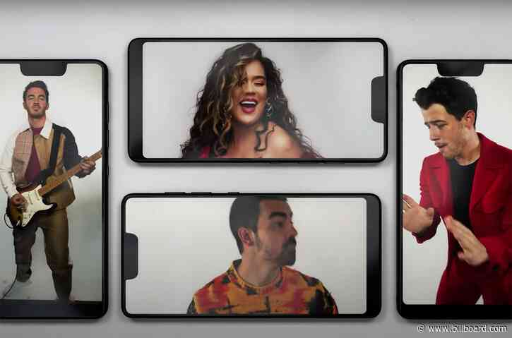 Jonas Brothers & Karol G Bust a Move Through a Phone Screen for ‘X’ Video