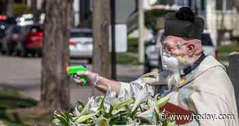 Viral photos show priest using squirt gun filled with holy water to bless churchgoers