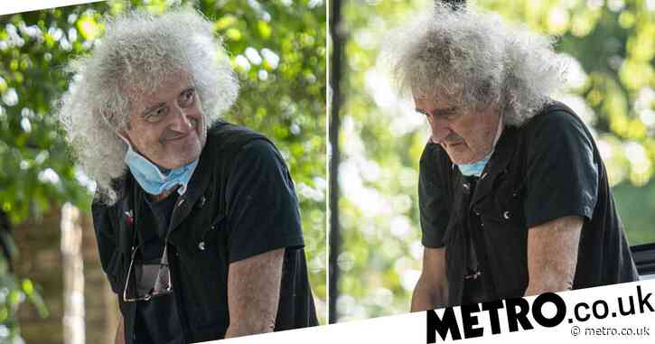Brian May heads out on crutches after suffering heart attack and undergoing operation to install three stents