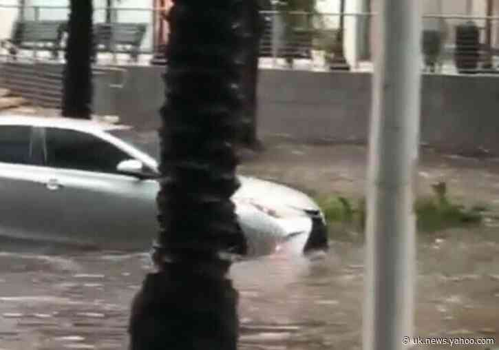 Cars and Pedestrians Navigate Heavy Flooding in Miami, Florida