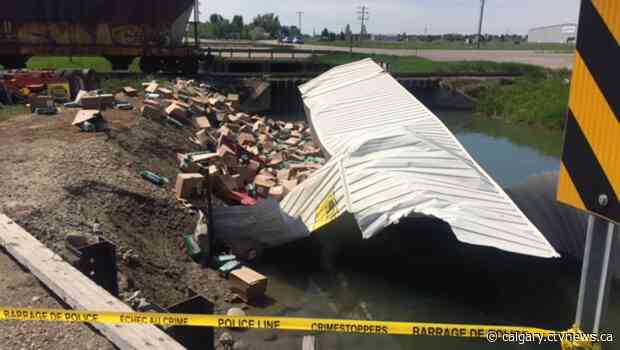 Collision with train sends trailer of pet store hay toppling into canal east of Lethbridge
