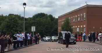 Hospital staff line route & clap at healthcare worker's funeral