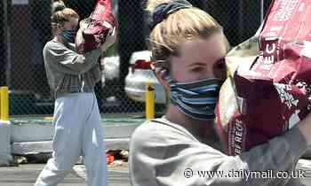 Ireland Baldwin proves all those trips to the gym have paid off as she carries 30lb bag of dog food