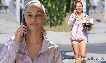 Cara Santana showcases her trim legs in tiny shorts as she beams on the phone in Los Angeles