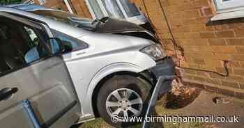 Minibus careers into flat after two-vehicle smash