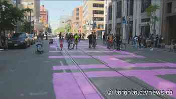 Protesters paint 'defund the police' on street in front of Toronto police headquarters