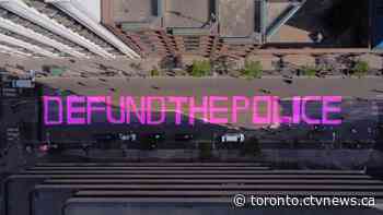Protesters paint 'defund the police' on street in front of Toronto police headquarters - CTV News