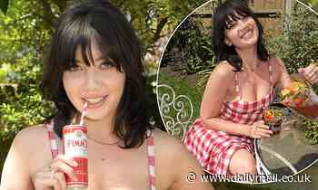 Daisy Lowe wears gingham dress as she poses with a Pimm's