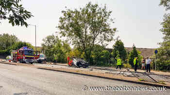 Road shut after car flips onto its roof