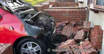 Car bursts into flames after smashing into house wall