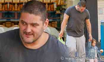 Brendan Fevola walks hand-in-hand with his 18-month-old daughter Tobi after buying her a cupcake