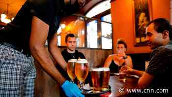 Plastic screens, tracings apps and table service. English pubs reopen on bittersweet day