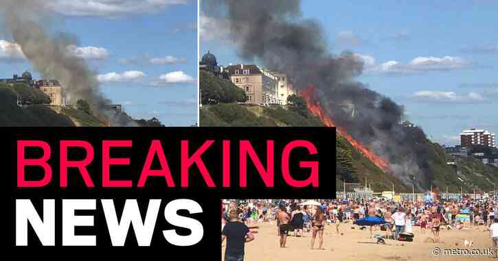 Beach evacuated after cliff face catches fire ‘from hut’