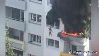 Crowd saves two children from burning building