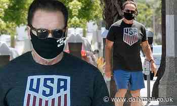 Arnold Schwarzenegger shows off toned arms in patriotic t-shirt as he wears his 'we'll be back' mask