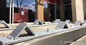 Edmonton bank blocks sitting space with metal triangle barriers - Global News