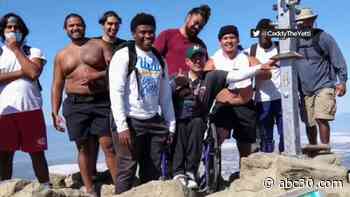 High school football players carry man in wheelchair up California summit