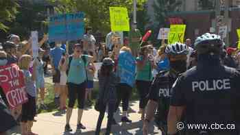Opposing groups demonstrate on same city street to express views on midtown homeless shelters