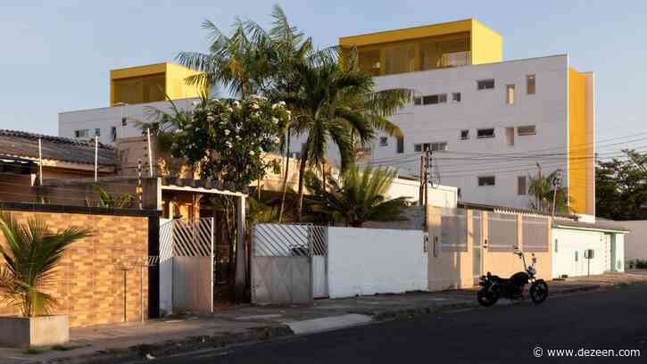 Yellow grates filter light into apartment building by Laurent Troost Architectures