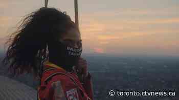 Jessie Reyez kneels atop CN Tower for 'O Canada' prior to Raptors' playoff debut