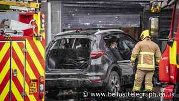 Woman taken to hospital after crash with PSNI vehicle sends car through shop window