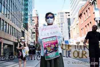 Demonstrators gather to protest treatment of migrant workers amid pandemic