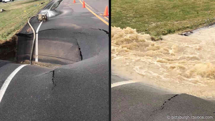 Crews Clear Puddle On Roadway To Reveal Giant Five-Feet-Deep Crater