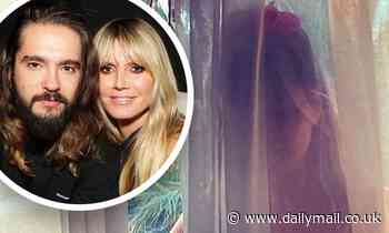 Heidi Klum, 47, poses naked behind a sheer curtain in a photo taken by