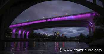 Who decides when the I-35W bridge is lit in color, and how is it done?