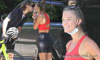 Nina Agdal showcases her enviable physique in a red sports bra as kisses her beau Jack Brinkley