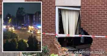 Car crashes in flats with person sleeping inside building taken to hospital