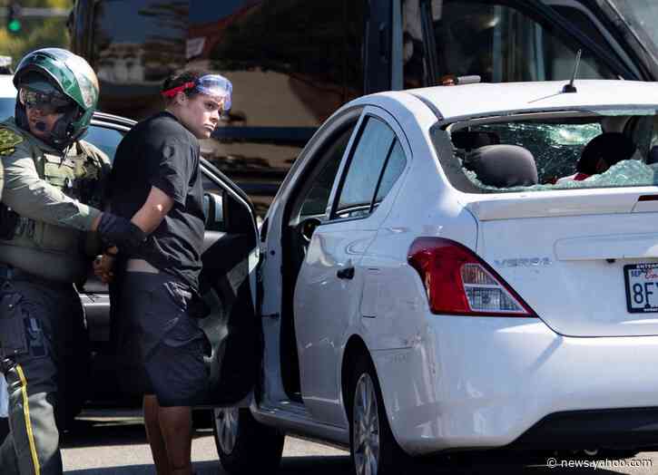Woman arrested after driving car into California protest