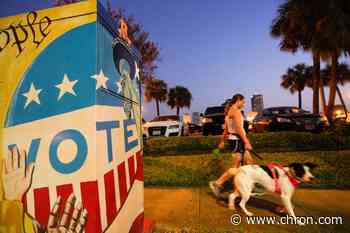 Harris County voters show off their stickers during the first day of early voting