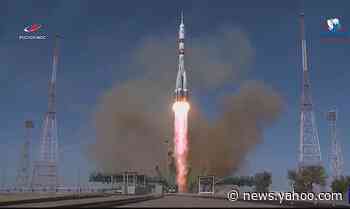 NASA astronaut, two cosmonauts, rocket toward space station