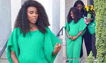 Pregnant Kelly Rowland cradles her blossoming bump in a slinky green gown as she steps out in style 
