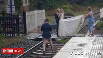 Couple posed on rail line for wedding shoot
