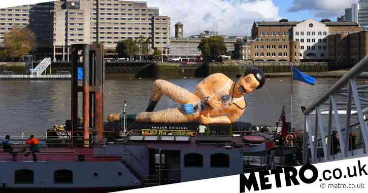 A giant inflatable Borat statue wearing nothing but a mask as a mankini is floating on the Thames ahead of the sequel’s release