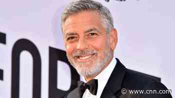 George Clooney cuts his own hair with a device attached to a vacuum cleaner