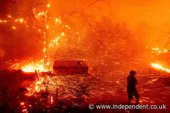 Californians flee as strong winds push fire through canyons