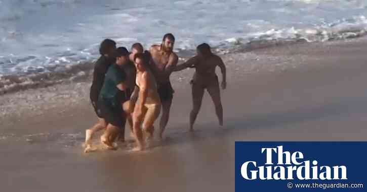 Australian pro surfer Mikey Wright saves woman struggling in Hawaii surf – video