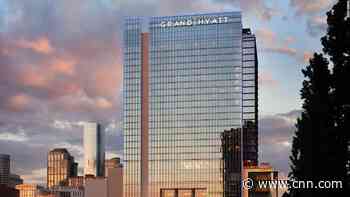 Two men with parachutes leap from hotel roof