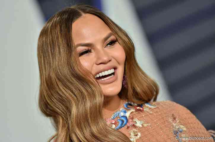 Chrissy Teigen Channels Cher’s ’90s Workout Videos For ‘The Best 38 Minutes of Fat-Burning Fun’