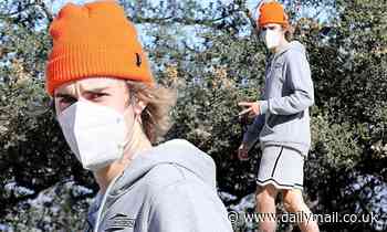 Justin Bieber flashes a peace sign as he takes a solo hike through the Hollywood Hills