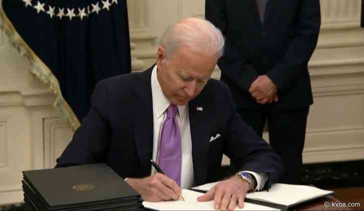 Biden signs burst of virus orders, requires masks for travel