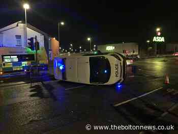 Police van flips on side in crash with BMW at Asda in Bolton