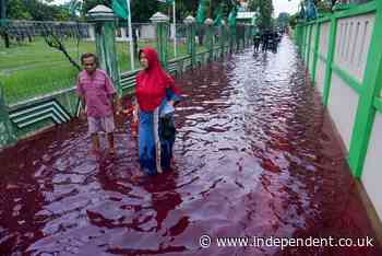 Blood-red flood swamps village in Indonesia