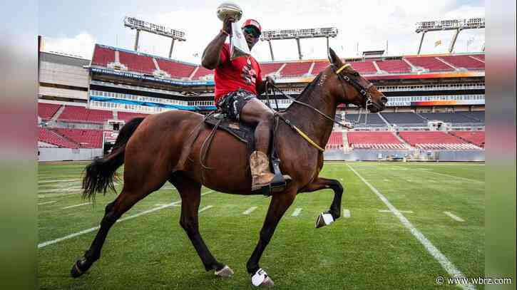 Devin White takes a victory lap around Tampa Bay stadium with trophy