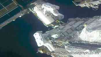Spacewalking astronauts prepare station for new solar wings