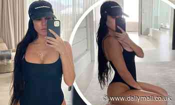 Kourtney Kardashian slips her famous curves into a sultry black one-piece to peddle Poosh products