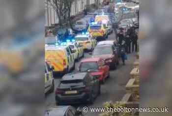 Large police presence with van and cars on Darwen street
